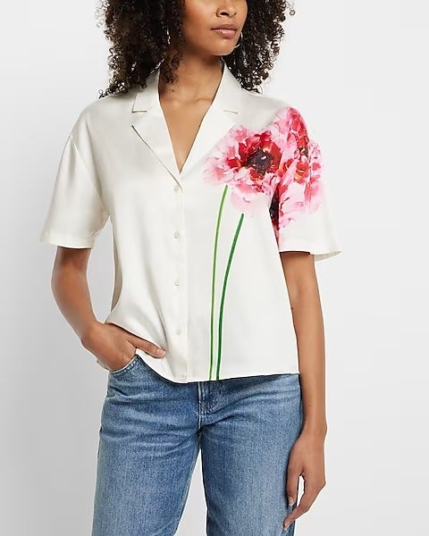 model in short sleeve white button down with green and pink flower printed up one side