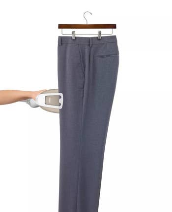 Image of someone using the fabric steamer on pants