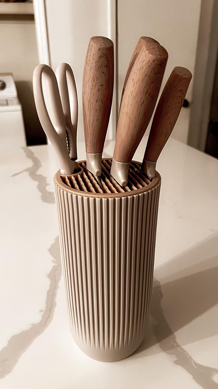 a reviewer's set of knives in a cylinder, ribbed container
