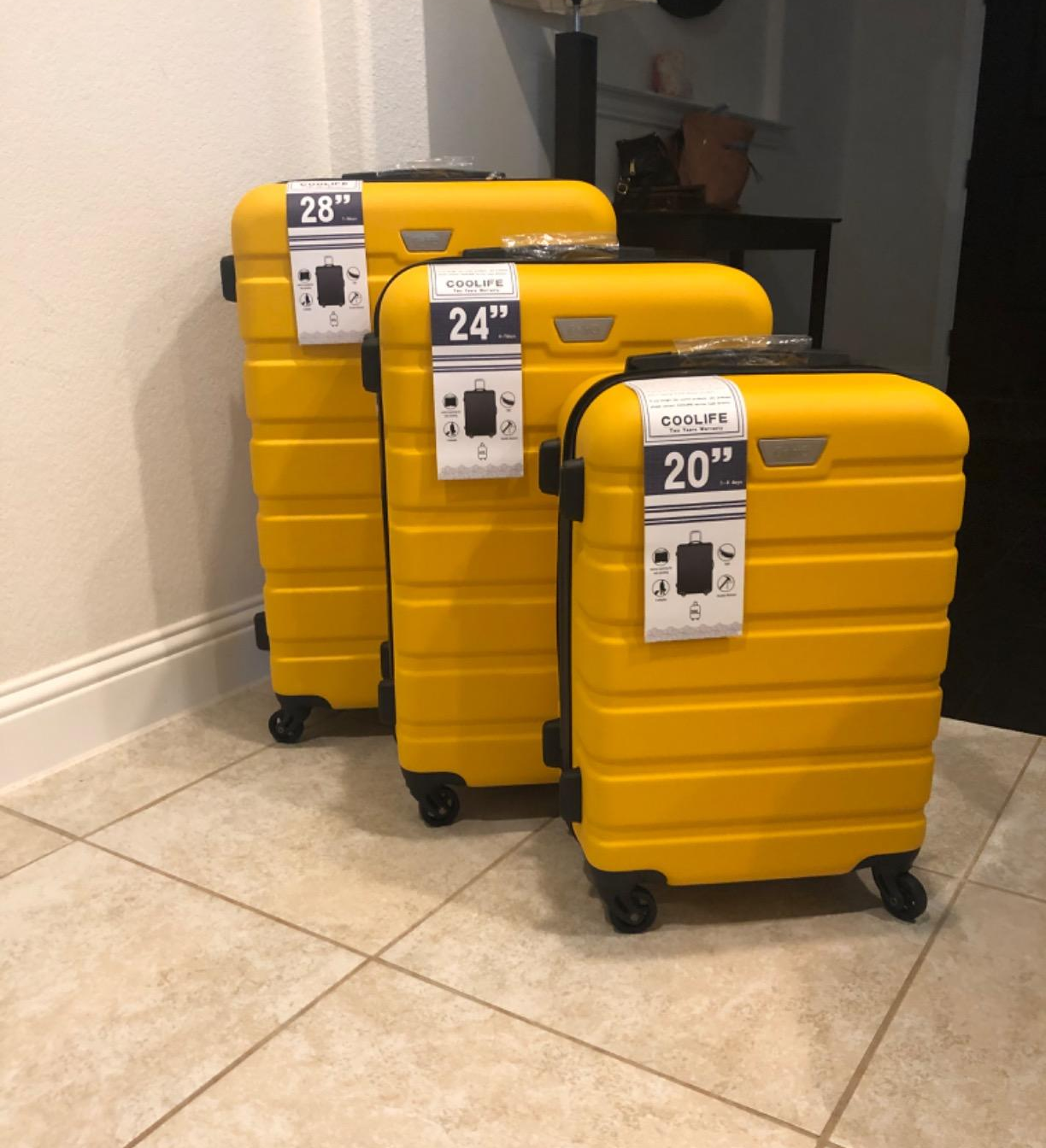Reviewer photo of the three piece luggage set in a bright yellow color