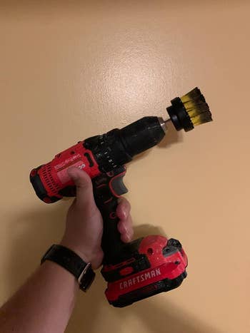 reviewer photo of them holding the red drill brush