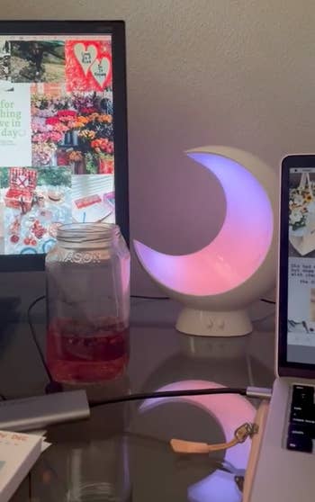 the moon lamp glowing pink and purple in a reviewer's desk setup