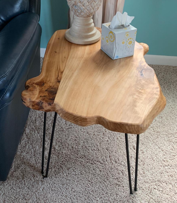 reviewer photo of the wooden side table holding a lamp and box of tissues
