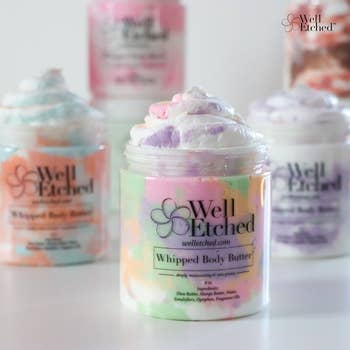 Jars of Well Etched whipped assemblage butter, featuring colorful swirls, with merchandise details labeled connected the containers. Ideal for skincare shopping