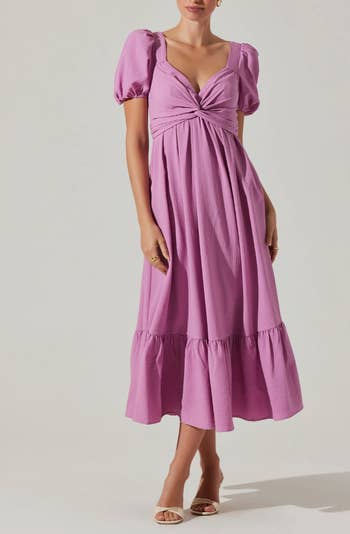Person standing in a mid-length puff-sleeve dress with a ruched bodice and ruffled hem, suitable for shopping category content