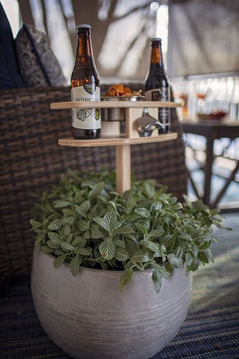 the wooden drink holder staked into a planter