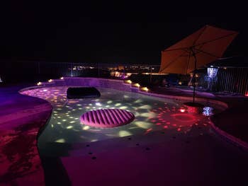 Nighttime presumption of a excavation with colorful floating lights and an inflatable, surrounded by illuminated seating