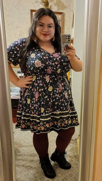 reviewer wearing the mini dress in black with a floral design