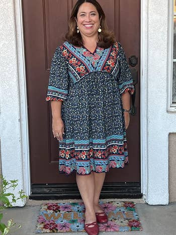 reviewer wearing the printed dress in blue and black print