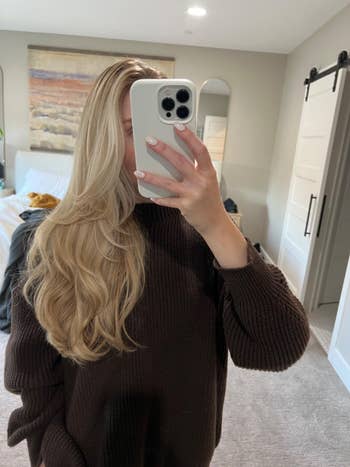 Person with long, styled hairsbreadth takes a reflector selfie successful a cozy room
