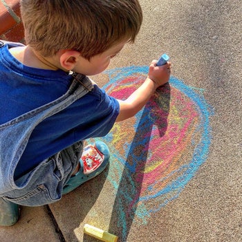 reviewer photo of their child drawing on the sidewalk