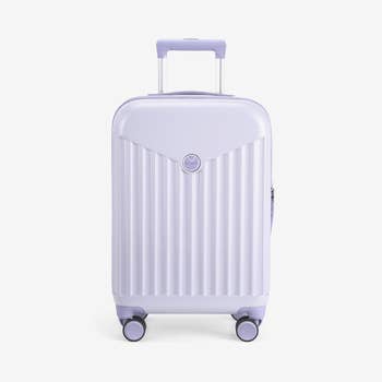 A purple hard-shell cabin-size luggage 