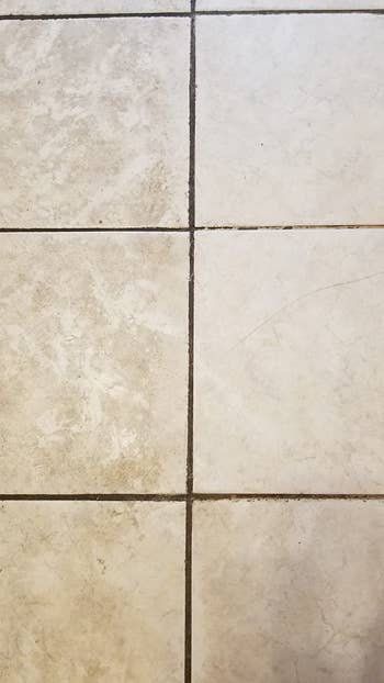 a reviewer photo of tiles that are dirty on the left side and clean on the right 