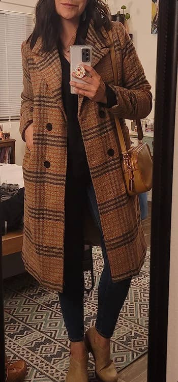 A reviewer taking a mirror selfie while wearing the coat