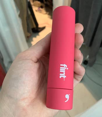 same reviewer holding the pink lint roller, but retracted and compact