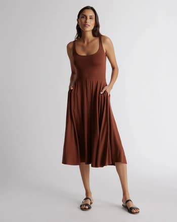 a model posing in a brown midi tank top dress with black sandals