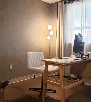  review's floor lamp with three spherical lights in corner of office behind desk
