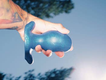 Model holding large blue butt plug