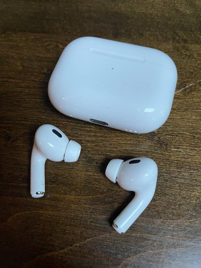 White wireless AirPods and their charging lawsuit  connected  a woody  surface