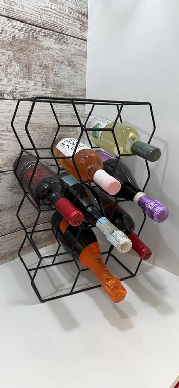 reviewer's black, geometric wine rack with various bottles