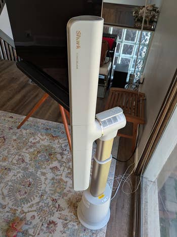 Tower-style instrumentality   with adjustable tallness  and integer  controls placed connected  a patterned rug adjacent   a window