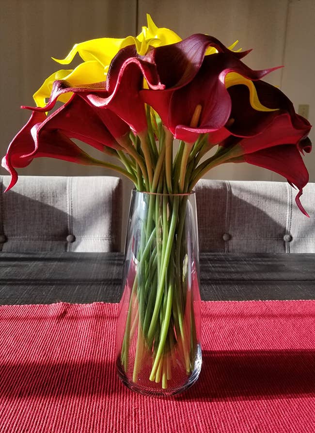 Reviewer image of clear glass round vase with red and yellow flowers on a red tablecloth
