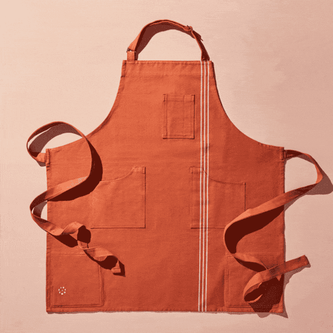 a gif of the apron zooming in on the built-in pot holders, various pockets, built-in conversion chart, and hanging loop 