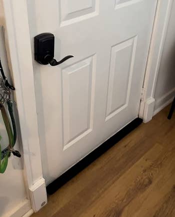 a reviewer photo of the under draft stopper installed on a door 