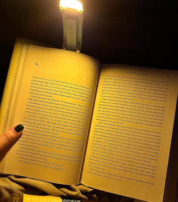 a reviewer using a book light to read in the dark