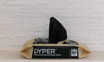 DYPER brand charcoal-enhanced baby wipes in a black package on a countertop