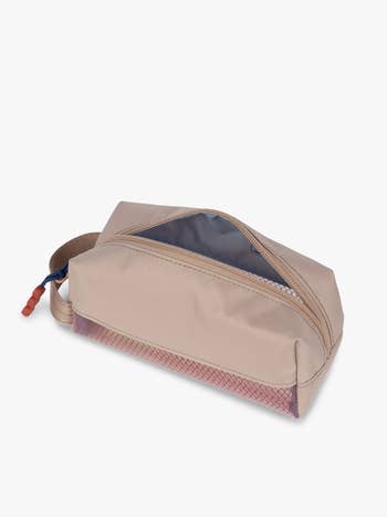 A beige zippered toiletry container with a handle, partially unfastened to uncover a grey interior. Perfect for organized question oregon regular use