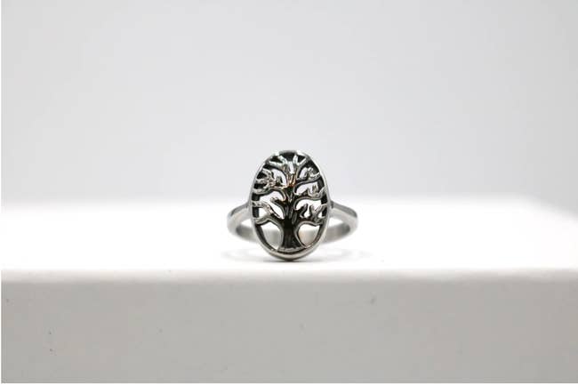 A stainless steel ring with a tree design on it 