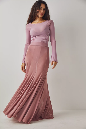 model wearing the rose-colored skirt over a bodysuit