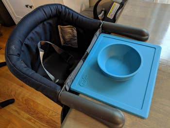 reviewer image of the blue bowl/placemat on a table in front of a high chair