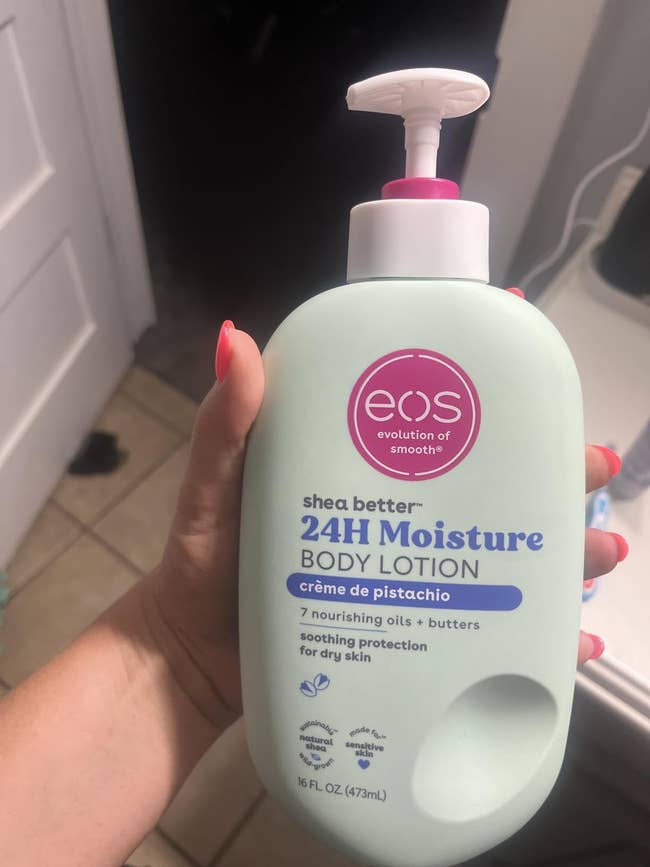 Hand holding EOS Shea Better Body Lotion, 24H Moisture, Crème de Pistachio, soothing protection for dry skin, 16 fl oz