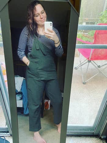 reviewer in olive overalls with their hand in one of the pockets