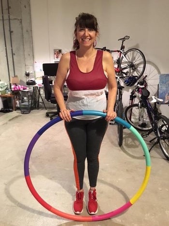 same reviewer holding hula hoop in a vertical position