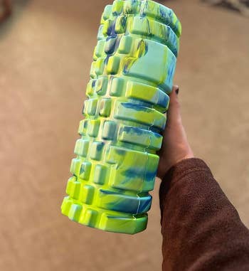 reviewer holding foam roller in alien lime green color