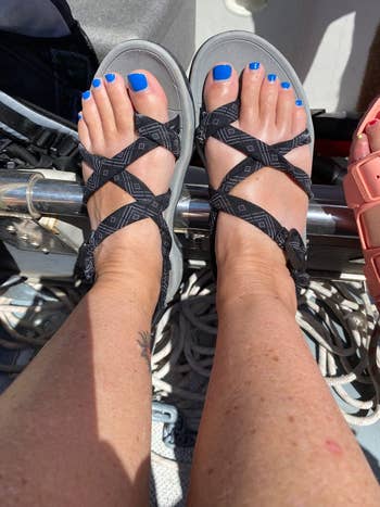 Person wearing strappy sandals with geometric patterns