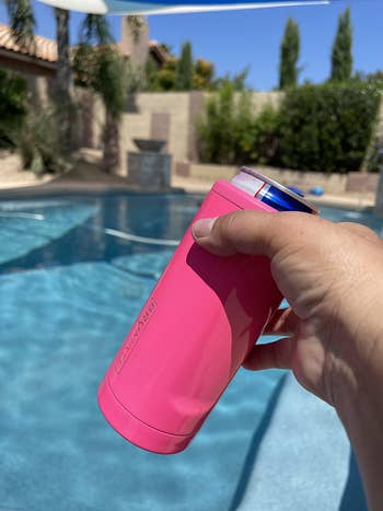 a review photo of someone sitting by the pool with their cup holder