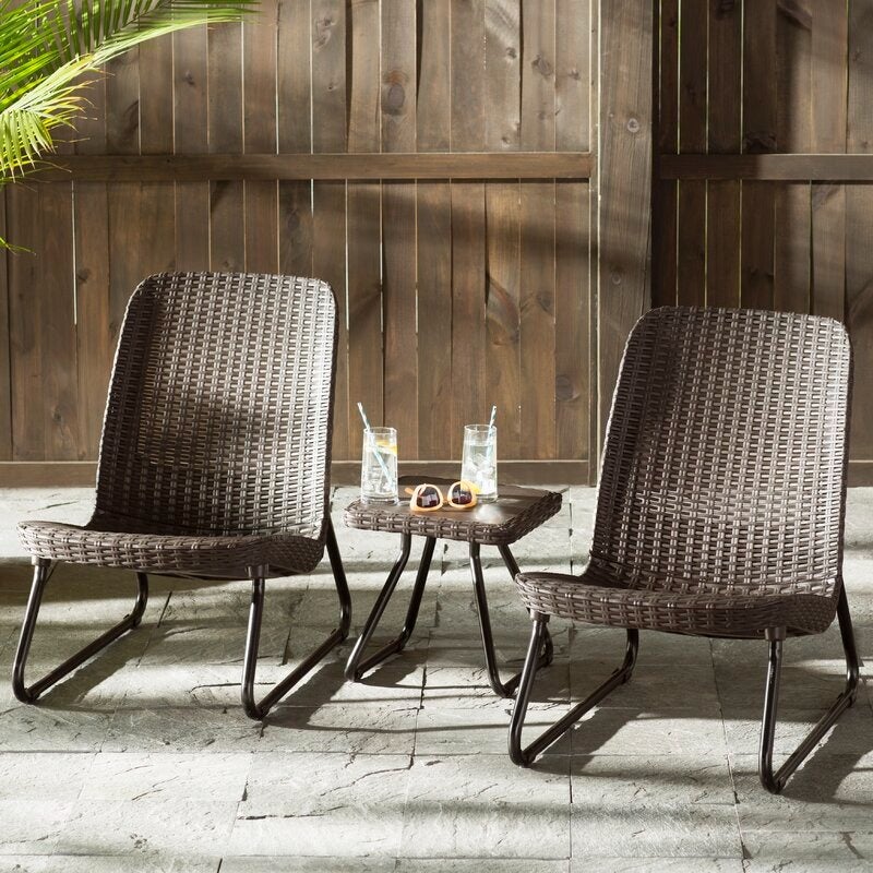 the espresso brown set on a patio, including two wicker chairs and a table