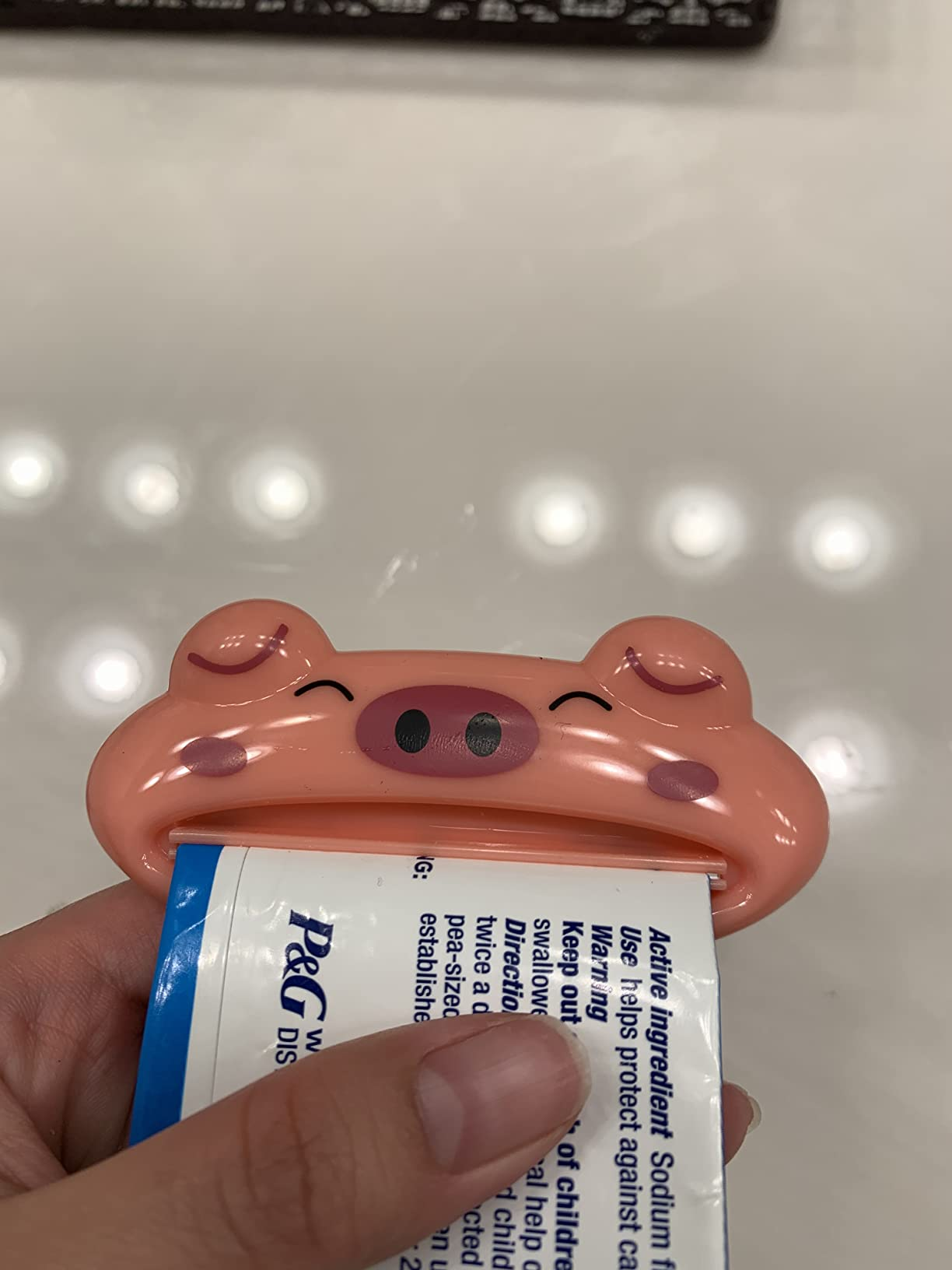 A reviewer using the tube squeezer for toothpaste