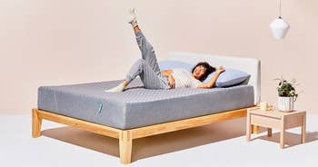 a model lying on a gray mattress