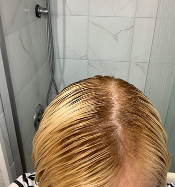 same reviewer's after photo showing their roots blending in with their blonde hair much more after using the root touch-up