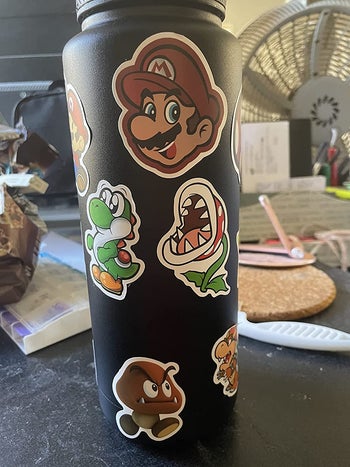 a reviewer's water bottle with mario-themed stickers on it
