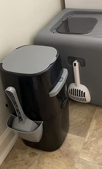 the black and gray litter genie with a handle in the side for storing a cooper