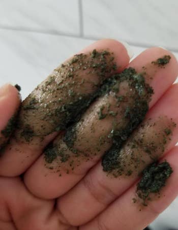 Close-up of a hand with green exfoliating forumla 