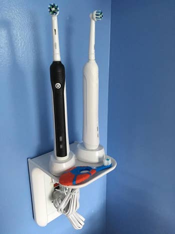reviewer photo of the white outlet shelf holding two electric toothbrushes
