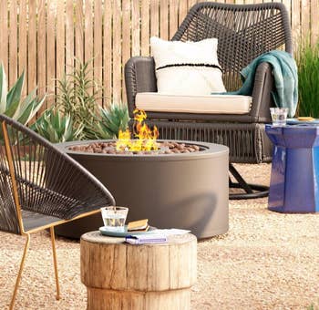 Image of the round black fire pit next to chairs