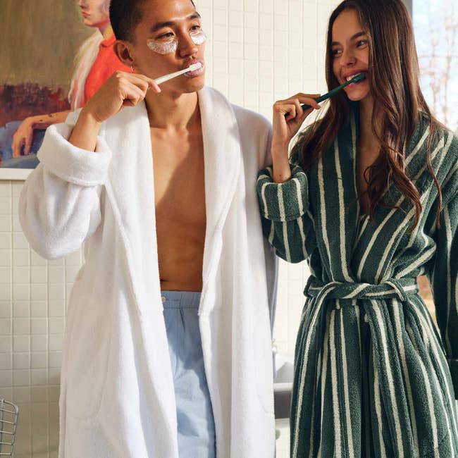 Two radical successful bathrobes, 1 successful achromatic and 1 successful striped, brushing teeth successful a bath setting